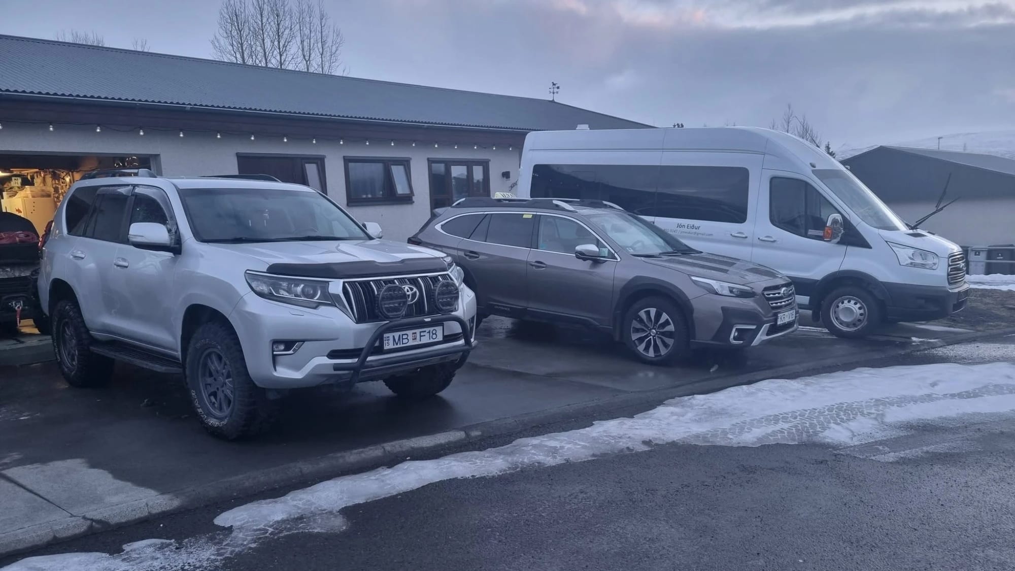 Leigubíll með taxaskilti og hvít smárúta merkt Jón Eiður